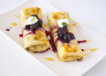 Crepes filled with cottage cheese and blueberry sauce